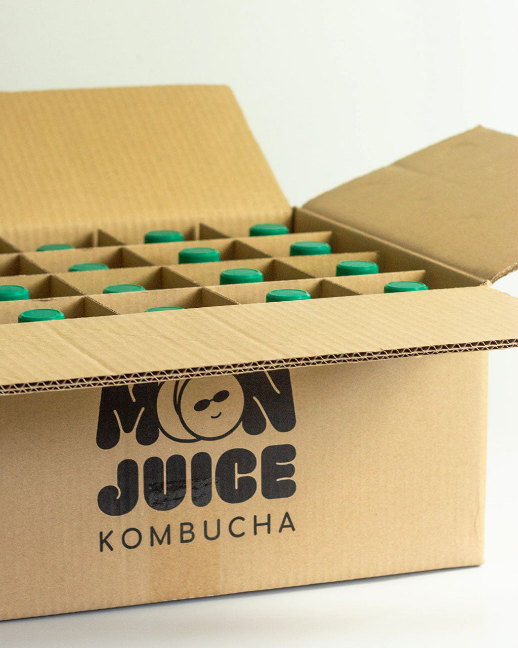 Carton with "Moon Juice Kombucha" branding, with 20 bottles in it