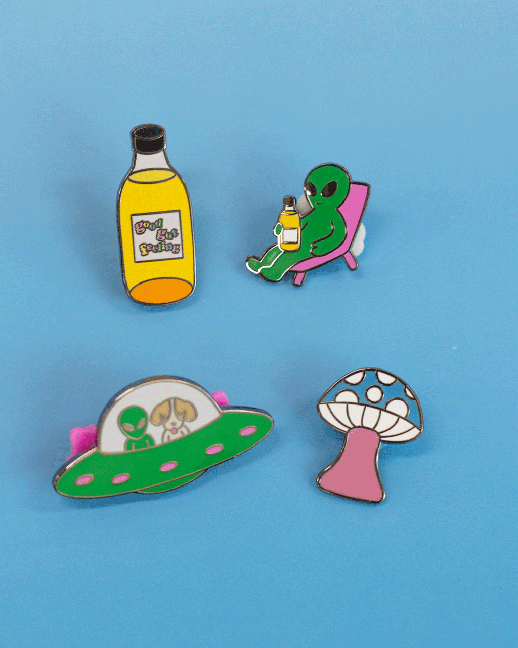 A gif of 4 Moon Juice Kombucha enamel pins, featuring the various pin backings.