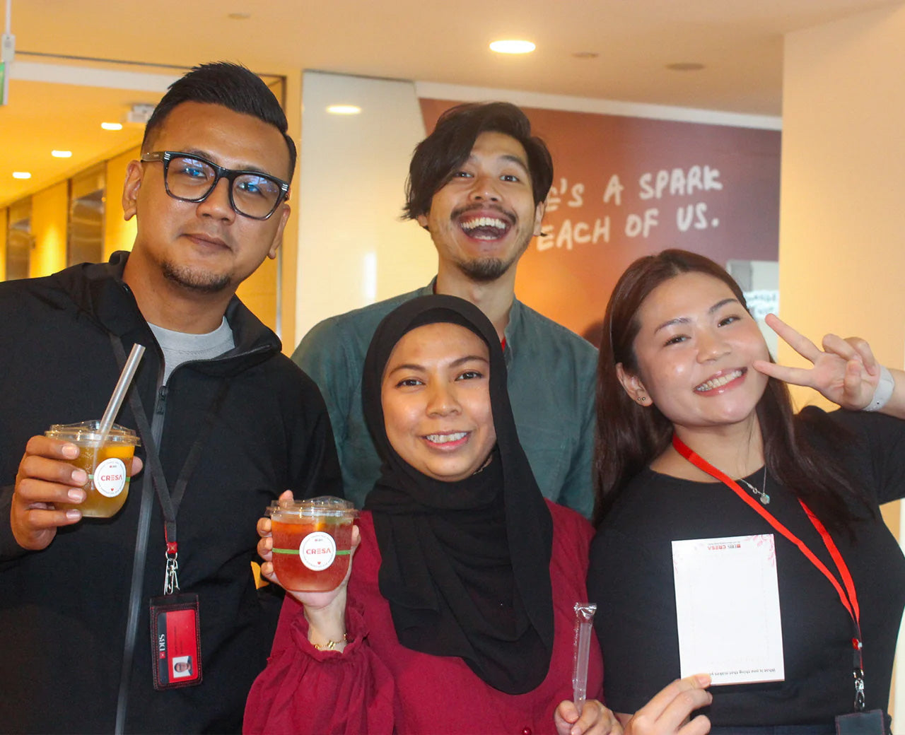 Four smiling customers enjoying kombucha at a wellness event for DBS.