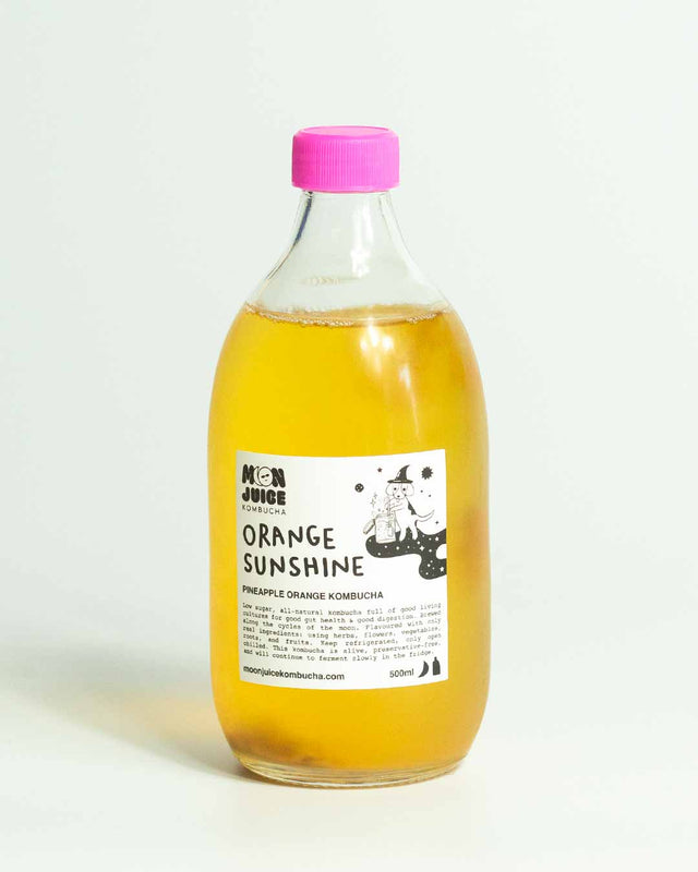 A 500ml bottle of Orange Sunshine (Pineapple Orange Kombucha) with a pink cap against a clean white background.