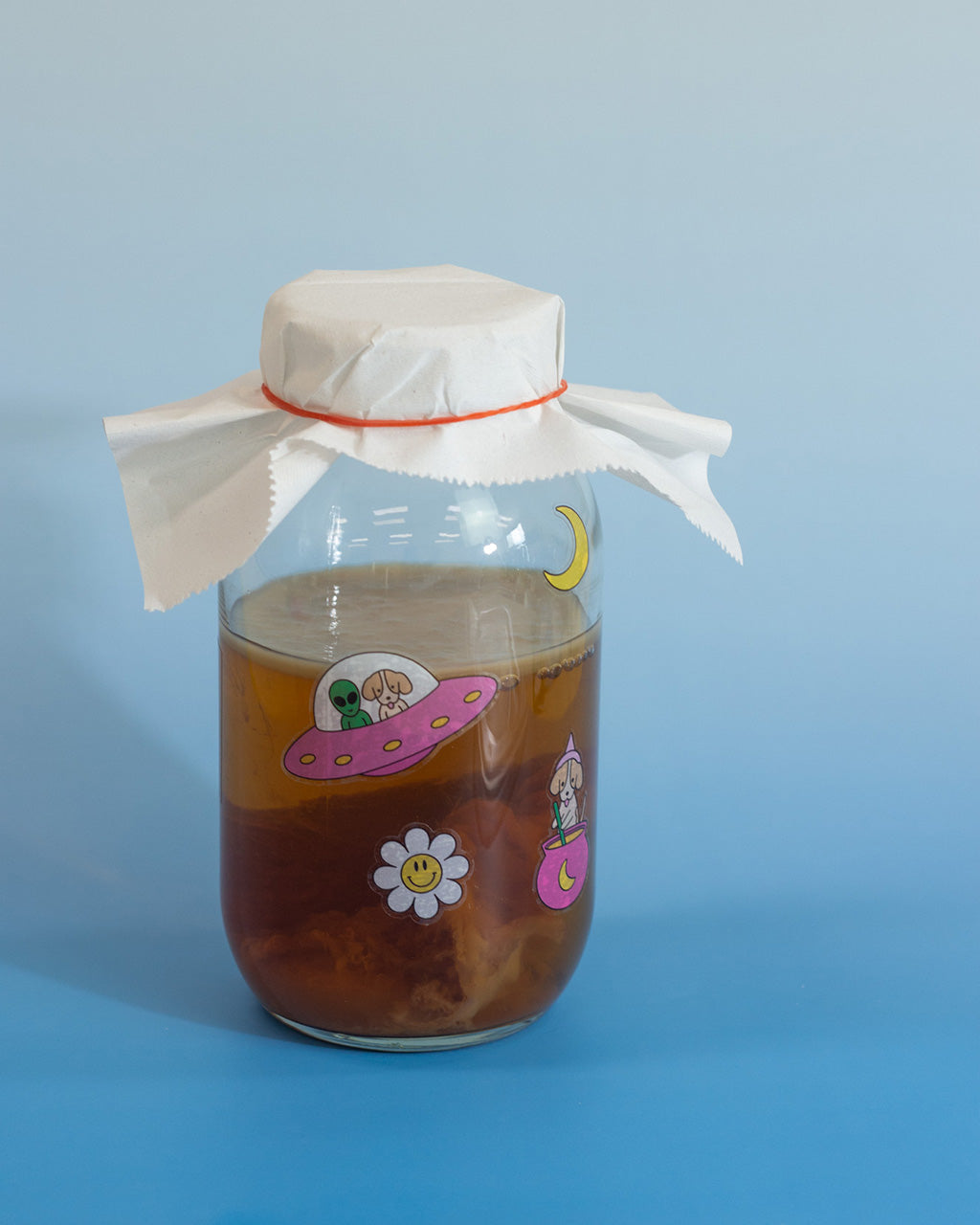 Jar of kombucha pasted with 4 Moon Juice Kombucha stickers