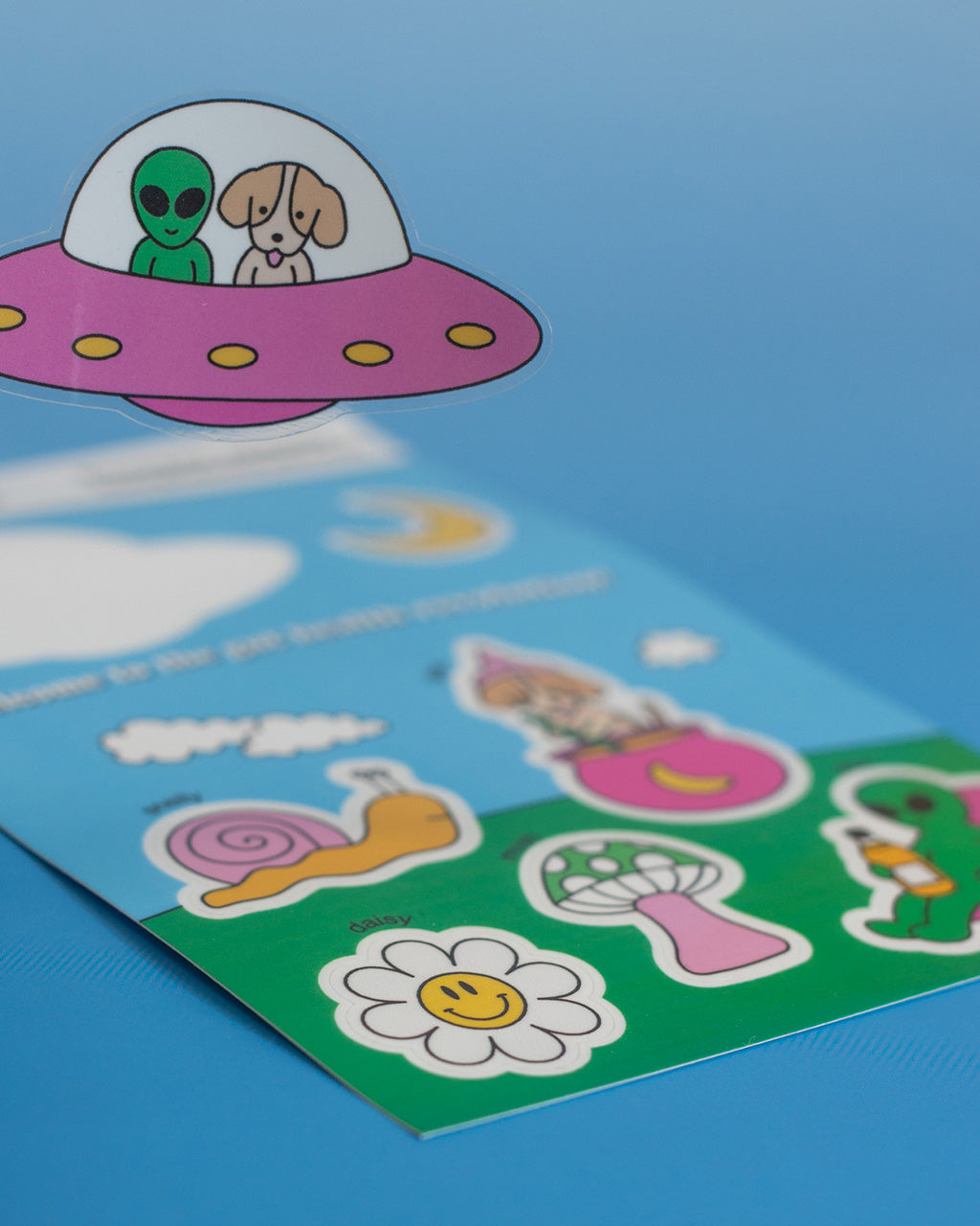 Close up of a UFO sticker, with the rest of the sticker sheet in the background.