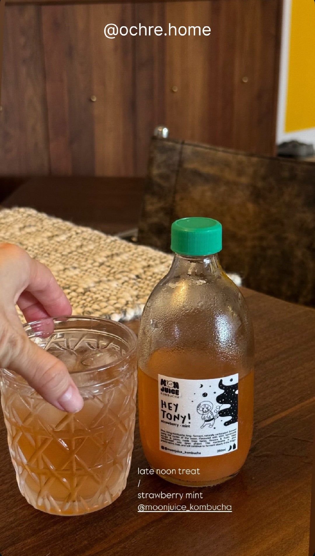 Aesthetic table-top shot of Hey Tony! strawberry mint kombucha in a cup next to the bottle. Taken by @ochre.home