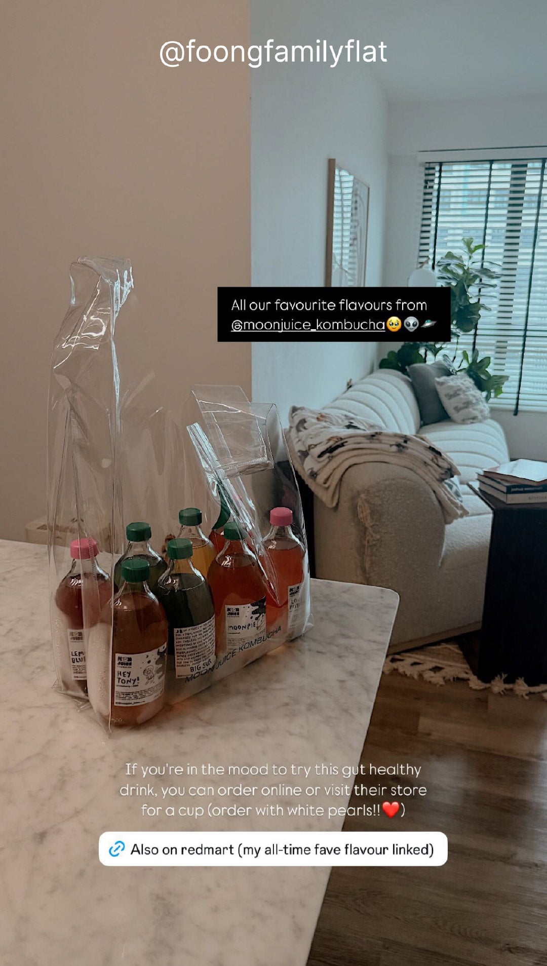 8 Moon Juice kombucha bottles packed in a clear jellybag on a kitchen island, with a stylish living room in the background. Taken by @foongfamilyflat