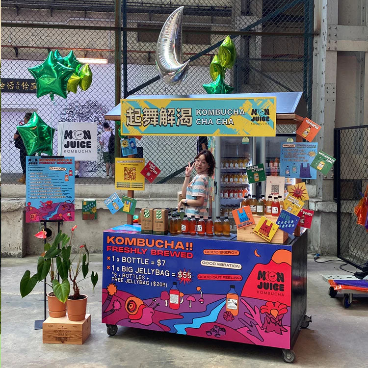 Our booth featuring bottled kombucha in standing chillers at Clang! 2023, a Chinese indie music festival 