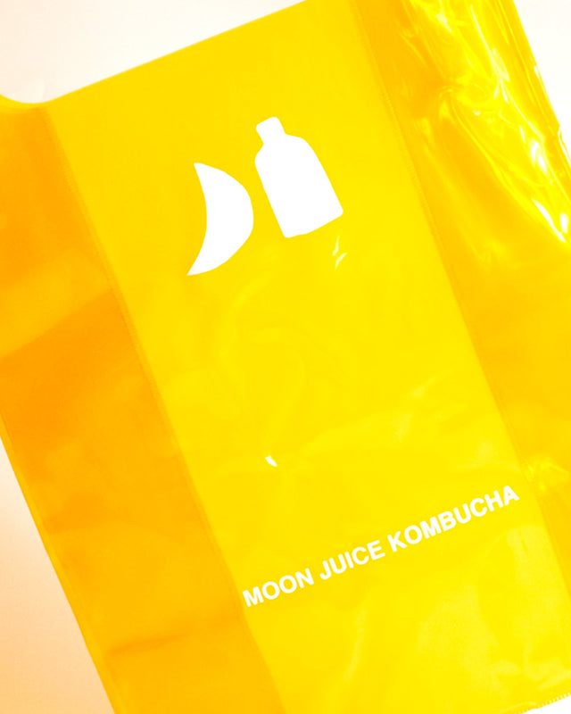 Bright orange Moon Juice Kombucha jellybag with a white logo and text, photographed close up against a light background.